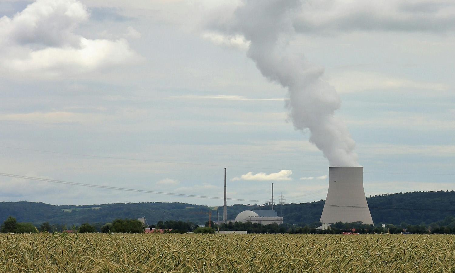 A wide shot of a field and nuclear reactor. 