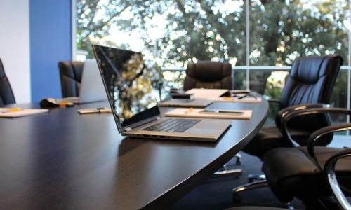 An empty meeting room with an open laptop