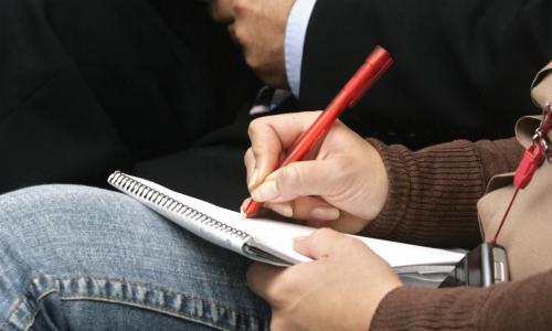 Reporter writing in notebook