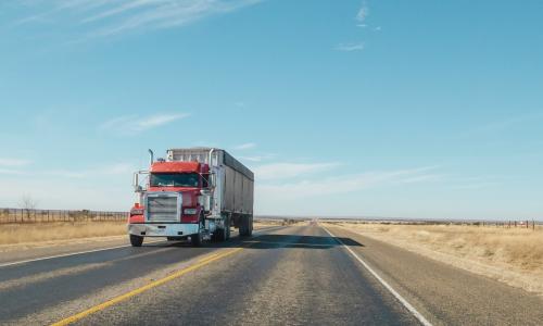 A semi-truck drives on a highway.