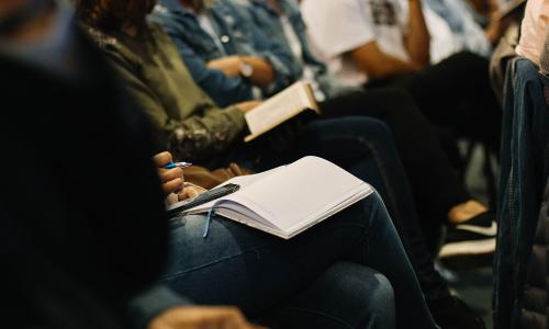 People sitting in church holding bibles.