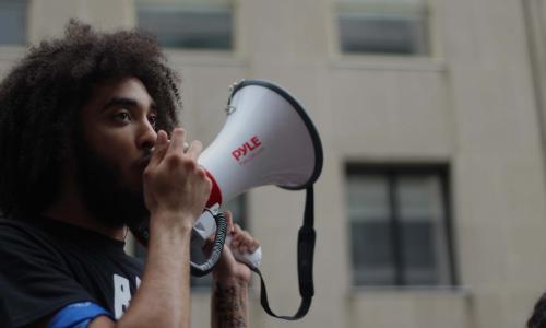 Young protester holds megaphone.