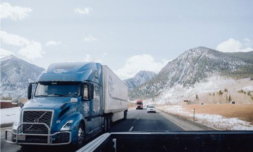 Semi truck driving away from mountains in Colorado