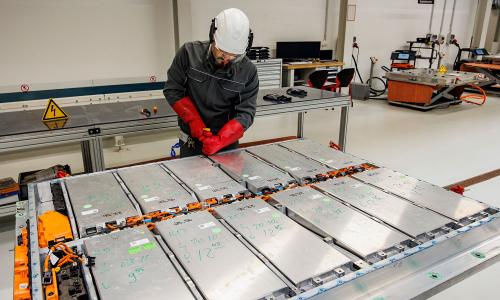 Volkswagen employee demonstrating disassembly of an electric car battery 