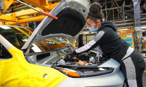 UAW Local 5960 member Kinethia Black fills the brakes of a 2022 Chevrolet Bolt EUV during vehicle production