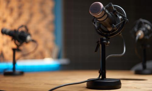 A podcasting setup with microphones on short desk stands.