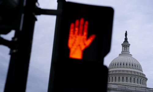 A stop sign in front of the US Capitol building.