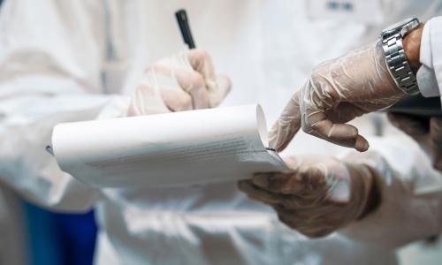 Two scientists looking over a clipboard. 