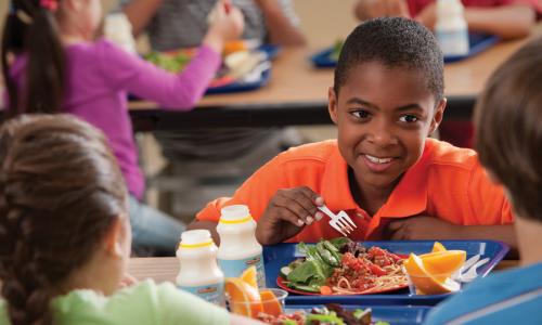 Young kids at a lunch table.